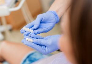 dentist holding dental bridge