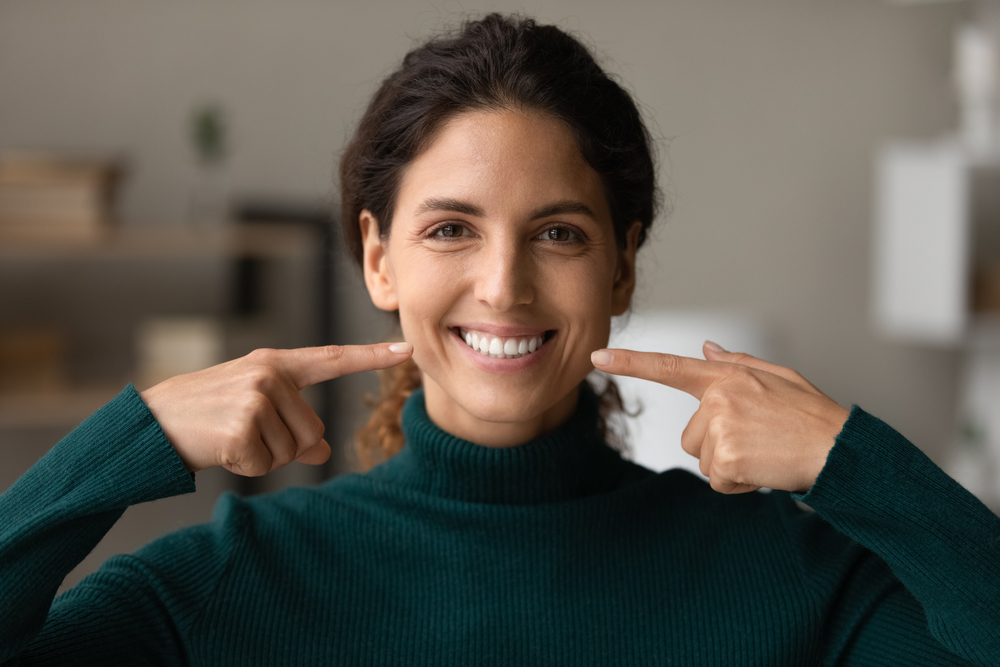 woman pointing to her perfect smile