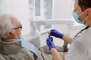 dentist showing patient model of implant