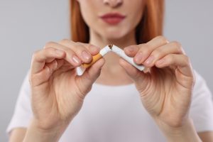 woman breaking cigarette in two