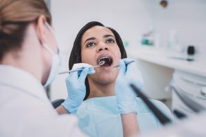 dentist observing woman's teeth